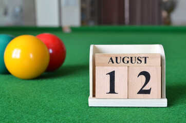 August 12, number cube with balls on snooker table, sport background.