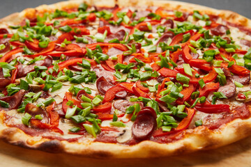 Pizza with a large number of toppings: hunting sausages, onions, cheese and bell pepper
