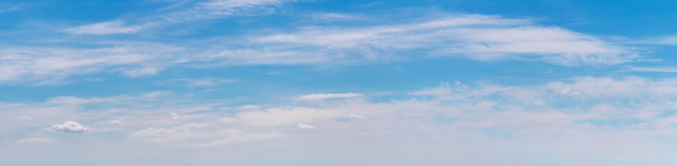 Panorama of the blue sky with white clouds lined up in a row