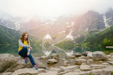 Naklejka premium woman relaxing on the lake and mountains sunny landscape