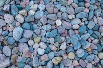 Many colorful round rocks of the coastal area photographed from above