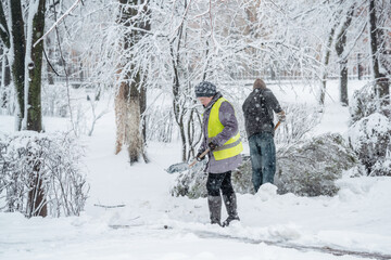 Fototapeta na wymiar Workers sweep snow from road in winter.