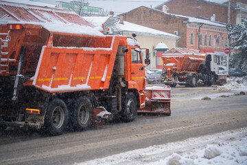 Snowplow clears the road from snow in the city