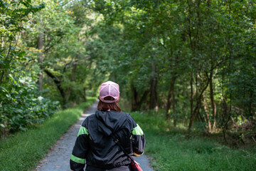 Obraz premium person walking in the woods along a path