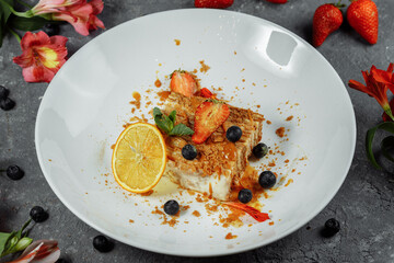 napoleon cake with caramel sauce. Delicate puff pastry cake with custard and caramel sauce decorated with strawberries, blueberries and mint
