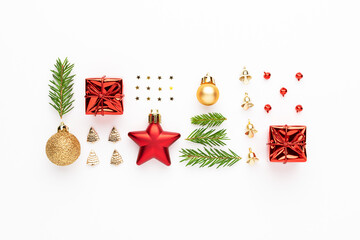 Christmas composition. Fir tree branches, golden balls, red stars, gifts, confetti and bells at white background. Christmas flat lay.