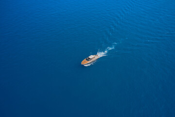 Obraz premium Aerial view luxury motor yacht. Yachts at the sea surface. High-speed yacht of white color on blue water in the rays of the sun top view. Travel - image.