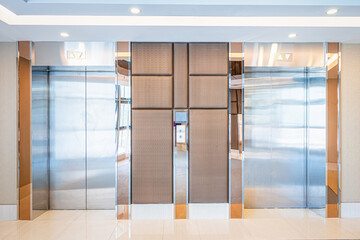 Modern steel elevator cabins in a lobby Hotel or office building.