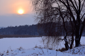 
winter landscape frozen river and setting sun