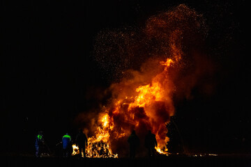 Fototapeta na wymiar Ancient tradition of Epiphany fires in Friuli, Italy. Burning of a straw effigy. Farewell to winter, arrival of spring