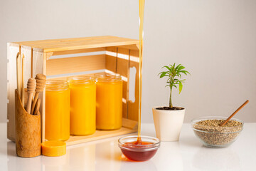 Jars of CBD honey, marijuana plant and hemp seeds