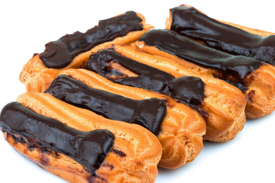 Group of tasty eclairs with custard and chocolate icing on white background. Sweet pastry products.