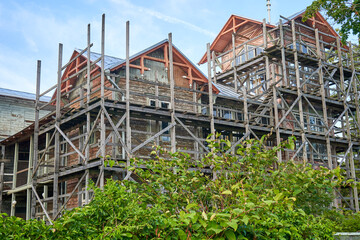 Old wooden building under renovation with scaffolding around it. 