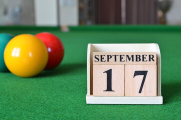 September 17, number cube with balls on snooker table, sport background.