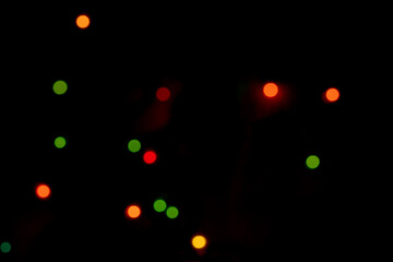Blurry colored Christmas holiday lights on a black background