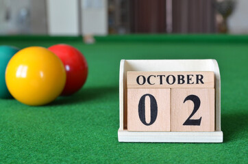 October 2, number cube with balls on snooker table, sport background.