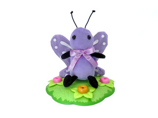 Butterfly Plush Toy sitting in a flower garden on white background