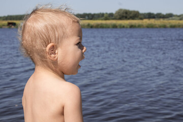 a beautiful little child on the river bank