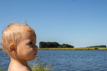 a beautiful little child on the background of the river