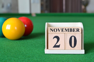 November 20, number cube with balls on snooker table, sport background.