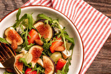 vegetarian salad with rucola, figs, blue cheese, strawberries, grapes, Autumn salad. Long banner format, top view