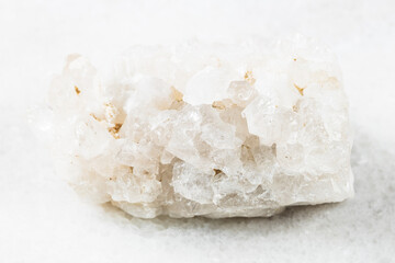 closeup of sample of natural mineral from geological collection - unpolished matrix of colorless Rock crystals (rock-crystal) on white marble background from China