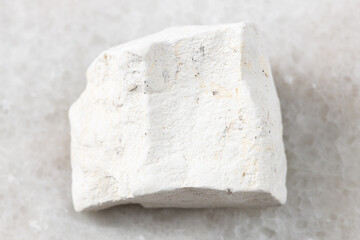 closeup of sample of natural mineral from geological collection - rough Chalk stone on white marble background from Voronezh region, Russia
