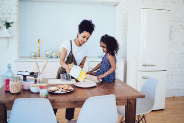 Black girl learning to cook with mother