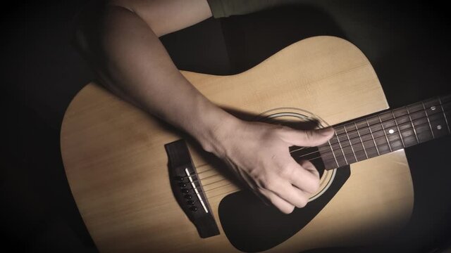 Close to hand of the young man playing guitar.