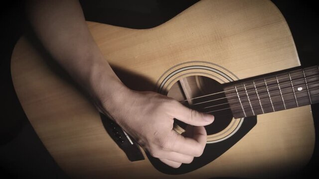 Close to hand of the young man playing guitar.