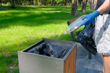 Volunteers with garbage bags are cleaning an area in the park. Garbage collection on weekends....