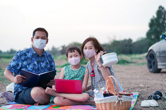 Happy Family Learning By Laptop And Having A Picnic In Outdoor With Wearing Face Mask