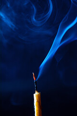 Smoke from an extinguished candle on a dark background.
