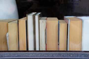 Old books on a windowsill of a cafe. Concept photo illustrating intellgence and learning.