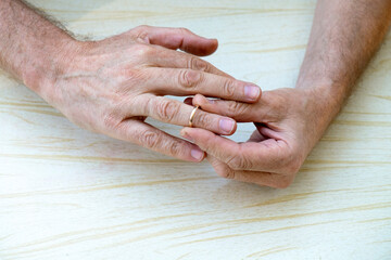 The man removes the wedding ring from his finger. Concept of problems in family life, divorce