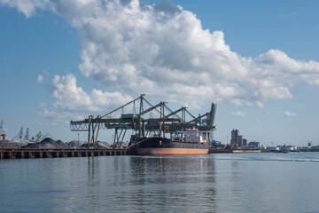 Logistics and transportation of Container Cargo ship and Cargo plane with working crane bridge in shipyard