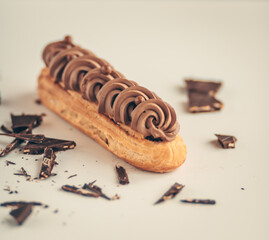 Selective focus to eclair with whipped cream and chocolate.  Closeup view.
