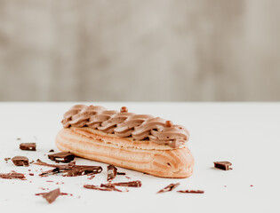 Selective focus to eclair with whipped cream and chocolate.  Copy space.