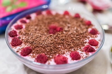 Raspberry cheesecake in glass bowl decorated with chocolate shavings