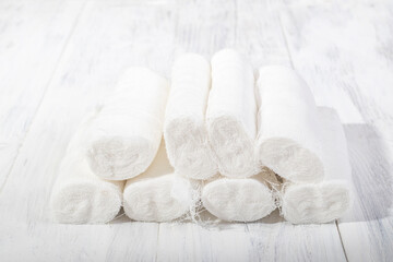 A white wooden background in retro style on it lies a bunch of medical bandage, the shape of a pyramid.