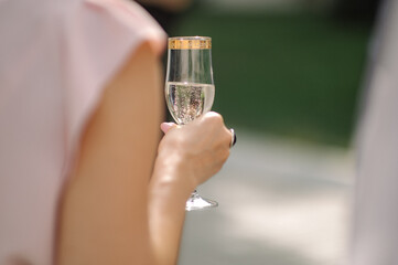 Woman holds a glass with a drink in hand close up