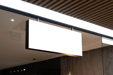 Mock up. Horizontal white empty signage on store shop front inside shopping mall