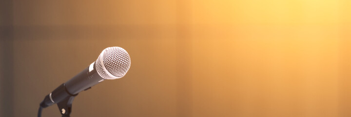 Microphone on abstract blurred of speech in seminar room or speaking conference hall light.