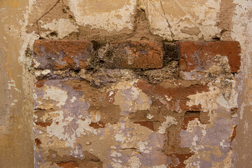 Background of an old wall with exposed bricks and old paint.