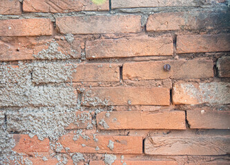 Background of an old wall with exposed bricks and an old screw.