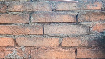 Fototapeta premium Background of an old wall with exposed bricks and an old screw.