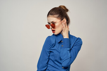 Portrait of a woman in sunglasses and a blue shirt on a light background cropped view of Model Copy Space