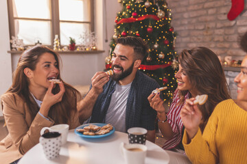 Friends eating Christmas cookies and drinking coffee