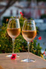Tasting of local rose wine in summer with sail boats haven of Port Grimaud on background, Provence, France