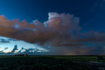 Storm cloud with heavy precipitation after sunset. Some clouds are blurred because of their motion during the long exposure time.